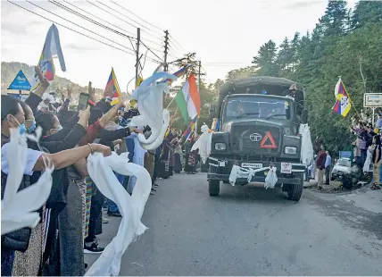  ?? —PTI ?? Tibetan community people greet Indian Army soldiers on their arrival at Panthaghat­i Chowk en route to Line of Actual Control amid the India-China border tension, in Shimla on Friday.