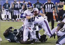  ?? BILL KOSTROUN — THE ASSOCIATED PRESS ?? After 10 games on the bench behind rookie Daniel Jones, Giants quarterbac­k Eli Manning, here getting tackled by the Eagles’ Fletcher Cox in a 2018 game, is eager for a chance to start again ... and he gets it against the Eagles Monday night.