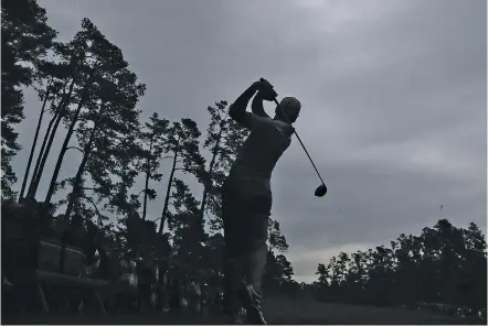  ??  ?? Sergio Garcia tees off on the 14th hole beneath a stormy sky just before play was suspended during practice Wednesday for the Masters at Augusta National Golf Club in Augusta, Ga.