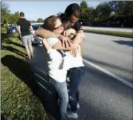  ?? ASSOCIATED PRESS ?? Family members are reunited with students outside Marjory Stoneman Douglas High School on Feb. 14 in Parkland, Fla. The shooting at a South Florida high school sent students rushing into the streets as SWAT team members swarmed in and locked down the...