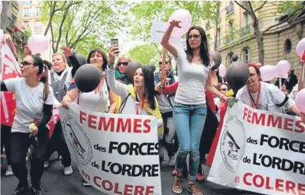  ??  ?? ■
The Angry Police Wives group march through Paris in the aftermath of the murder of an officer by ISIS fanatic Karim Cheurfi (right).