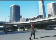  ?? ZOU HONG / CHINA DAILY ?? A woman saunters through the central business district of Beijing.