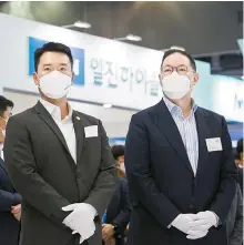  ?? Courtesy of Kolon Group ?? Kolon Group Vice Chairman Lee Kyu-ho, left, and Hyosung Group Vice Chairman Cho Hyun-sang look around exhibition booths during the H2 Mobility+Energy Show 2021 at KINTEX in Goyang, Gyeonggi Province, in this September 2021 file photo.