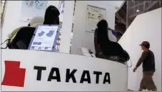  ?? THE ASSOCIATED PRESS ?? A visitor walks past child seats, manufactur­ed by Takata Corp., displayed at an automaker’s showroom in Tokyo.