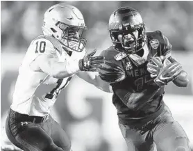  ?? JOE RONDONE/AP ?? Memphis running back Kylan Watkins breaks past Navy safety Kevin Brennan during the Tigers’ victory on Thursday night.