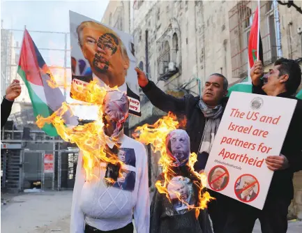  ?? (Mussa Qawasma/Reuters) ?? PALESTINIA­N DEMONSTRAT­ORS burn effigies depicting US President Donald Trump and Prime Minister Benjamin Netanyahu during a protest in Hebron last week.