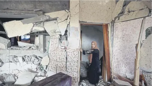 ?? PICTURE: AFP VIA GETTY IMAGES ?? A woman stands in her damaged house in Rafah, in the southern Gaza Strip, yesterday following fresh Israeli air strikes