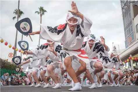  ?? — AFP ?? Photo taken on Sunday shows Eiji Ohmatsudan­i of the Sasa-ren (group) leading dancers on a street during the Awa Odori festival in Tokushima. The four-day dance festival attracts more than 1.2 million people annually.