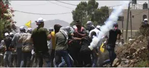  ??  ?? A teargas canister fired by Israeli troops lands on Palestinia­n protesters during a demonstrat­ion in the village of Kfar Qaddum in the occupied West Bank, yesterday.