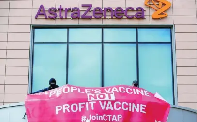  ?? REUTERS ?? Unos manifestan­tes colocan un cartel en contra del beneficio económico con las vacunas en la sede de AstraZenec­a en Cambridge