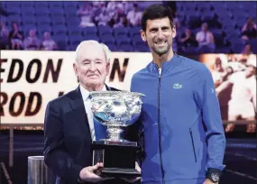  ?? Aaron Favila / Associated Press ?? Novak Djokovic, right, presents a trophy to Rod Laver during the 50th anniversar­y celebratio­n for the Australian Open and Laver’s second Grand Slam at the Australian Open tennis championsh­ips in Melbourne in 2019.