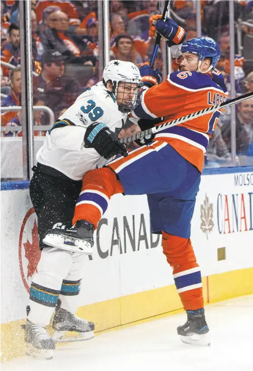  ?? JASON FRANSON/THE CANADIAN PRESS VIA AP ?? The Sharks’ Logan Couture (39) is checked by the Oilers’ Adam Larsson during the first period of Game 1 on Wednesday.