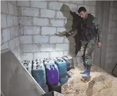  ?? AP PHOTO ?? TESTING: An official gets chemical weapons samples from Syria’s Douma yesterday, two weeks after a deadly attack.