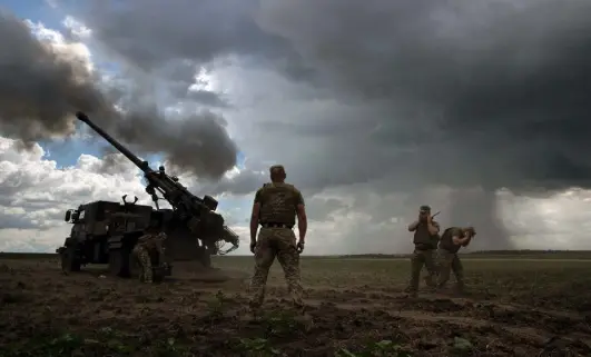  ?? Photos by Tyler Hicks, © The New York Times Co. ?? Ukrainian soldiers fire a howitzer donated by France at a Russian position in the Donetsk region of eastern Ukraine on Friday.