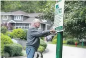  ?? JASON PAYNE/PNG FILES ?? Mick Webb posts bear aware signs in North Vancouver on Friday.