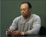  ?? SETH WENIG — THE ASSOCIATED PRESS FILE ?? In this March 20 photo, golfer Tiger Woods prepares to sign copies of his new book at a book signing in New York. Woods is receiving help to manage his medication­s.