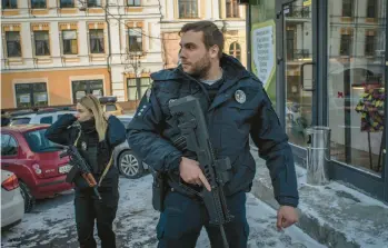  ?? LAURA BOUSHNAK/THE NEW YORK TIMES 2022 ?? Officer Svitlana Lukianenko­va, left, and Patrol Police colleague Officer Stanislav Skrypnyk work Dec. 14 in Kyiv, Ukraine. The Patrol Police have taken the lead in trying to ensure security for a traumatize­d public.
