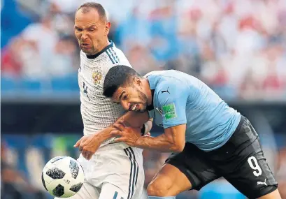  ?? REBECCA BLACKWELL/THE ASSOCIATED PRESS ?? Uruguay's Luis Suarez, right, battles Russia's Sergei Ignashevic­h for possession during Group A World Cup play Monday.