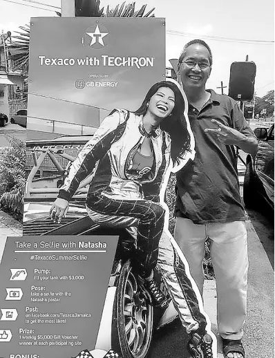  ?? CONTRIBUTE­D ?? Slain businessma­n Roger Chang (right) stands beside a promotiona­l cardboard cut-out of his daughter, Jamaica race car driver, Natasha Chang.