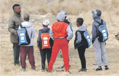  ??  ?? ALL EARS. A SANParks People and Conservati­on intern shows pupils how effective vultures are at cleaning the bush of dead animals, at the Golden Gate Highlands Park .