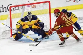  ?? Greg M. Cooper/Associated Press ?? Boston College forward Gabe Perreault (34) attempts a shot on Quinnipiac goalie Vinny Duplessis (37) while defended by defenseman Jayden Lee (15) during the first period on Oct. 7 in Hamden.