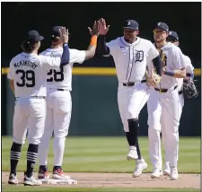  ?? (AP/Carlos Osorio) ?? Detroit right fielder Wenceel Perez (center) high-fives shortstop Javier Baez after the Tigers’ 4-2 win over the Texas Rangers on Tuesday in Detroit.