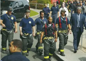  ?? (Lucas Jackson/Reuters) ?? EMERGENCY PERSONNEL walk away after saluting an ambulance carrying the body of fire battalion chief Michael Fahy away from the New York-Presbyteri­an Allen Hospital yesterday.