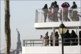  ?? MARY ALTAFFER—THE ASSOCIATED PRESS ?? Visitors to the Statue of Liberty take photos from onboard a ferry that will cruise the bay around the statue and Ellis Island, Saturday, Jan. 20, 2018, in New York. The National Park Service announced that the Statue of Liberty and Ellis Island would...