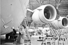  ??  ?? A maintenanc­e technician inspects a US Air Force Boeing C-17 Globemaste­r III airplane at the Boeing Co. Global Services and Support facility in San Antonio,Texas, last Thursday. Government figures last Friday are forecast to show GDP growth decelerate­d in the final three months of 2015, with a sharp slackening in inventorie­s by manufactur­ers and other businesses and a larger trade deficit behind the slowdown.