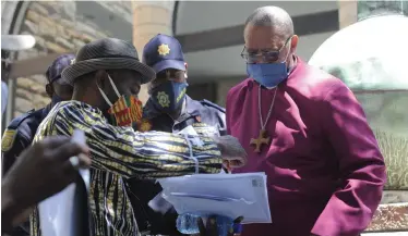  ?? | ARMAND HOUGH African News Agency (ANA) ?? A SMALL group of Nigerians in Cape Town protested against police brutality in their home country. They delivered a letter for the Archbishop of Canterbury, the Most Reverend Justin Welby. Here the letter is received by Reverend Joshua Louw at St George’s Cathedral.