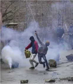  ??  ?? KASHMIR: A Kashmiri protester throws rocks at Indian security forces during a protest near the site of gun battle in Chadoora town, about 25 kilometers south of Srinagar, Indian controlled Kashmir yesterday. — AP