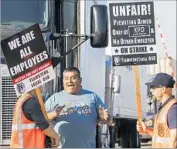 ?? Mark Boster Los Angeles Times ?? A TRUCK DRIVER trying to exit the XPO Logistics yard in the City of Commerce argues with a picketer.