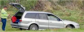  ??  ?? A police officer searches the car that was ditched by the wanted man in a paddock.