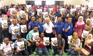  ??  ?? Shahrir (centre) and other Johor BN leaders pose for a group photo with housing scheme recipients. — Bernama photo