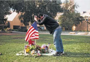  ?? Jenna Schoenefel­d / New York Times ?? Alfonso Gonzalez on Friday fixes an American flag set up at a makeshift memorial dedicated to the victims of a mass shooting at the nearby Borderline Bar &amp; Grill in Thousand Oaks, Calif.