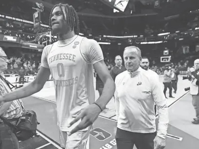  ?? BOB DONNAN/USA TODAY SPORTS ?? Tennessee forward Jonas Aidoo and coach Rick Barnes walk off the court after defeating Texas on Saturday during the second round of the 2024 NCAA Tournament in Charlotte, N.C.