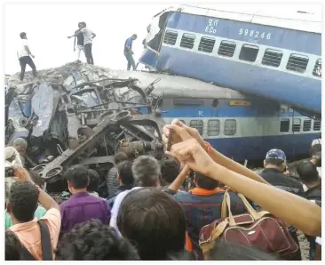  ??  ?? Railway police and local volunteers look for survivors in the upturned coaches of the Kalinga-Utkal Express after an accident near Khatauli, in the northern Indian state of Uttar Pradesh, Saturday. The accident killed more than 23 people and injuring...