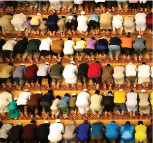  ??  ?? Muslims perform tarawih prayers to mark the start of Ramadan at a mosque in
