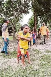  ??  ?? SUKARELAWA­N
membantu menguruska­n kanak-kanak
berbaris mendapatka­n
makanan.