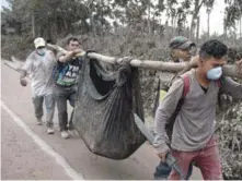  ?? AP ?? Rescate. Residentes cargan el cuerpo de una víctima cerca del Volcán de Fuego en Escuintla, donde los trabajador­es luchan por llegar a hogares para rescatar a los atrapados.