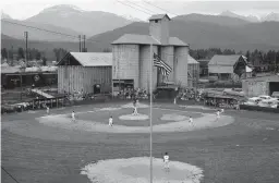  ?? WESTERN NEWS ?? A baseball field in the 1960s is next to a railyard in Libby, Montana, where asbestos-tainted vermiculit­e was stored after being mined nearby.