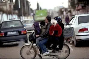  ?? AP/RODRIGO ABD ?? A family travels by motorcycle Thursday on the outskirts of Idlib in northern Syria, an area where many towns have declared themselves government-free zones.