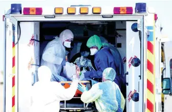  ?? AP ?? Medical staffs evacuate a patient infected with the Covid-19 virus from an ambulance before transporti­ng him into a French military helicopter heading to Switzerlan­d.