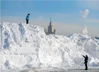  ?? [ APA/AFP/Natalia Kolesnikov­a ] ?? Ein Polizist ermahnt eine Russin auf einem Schneehauf­en. Zum Impfen kann man die Leute aber nicht zwingen.