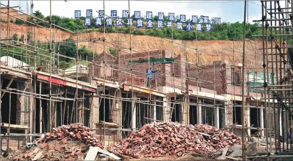  ?? LIU RANYANG / CHINA NEWS SERVICE ?? Workers build new houses for impoverish­ed families in Xionglumo village, Yunnan province.