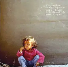  ?? — AFP ?? A displaced Syrian child from Raqa sits at a camp for internally displaced people in Ain Issa on Sunday.