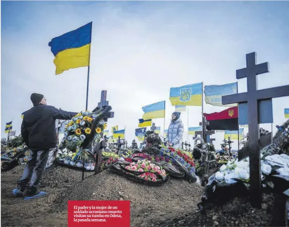  ?? Kay Nie ?? El padre y la mujer de un soldado ucraniano muerto visitan su tumba en Odesa, la pasada semana.