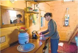  ??  ?? Williams lights a burner for a teakettle. She gets by with no oven or refrigerat­or. There is a sink and a toilet but no running water. Lights are solar powered.