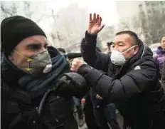  ?? AFP ?? Push and pull Left: Chinese police push away journalist­s and Pu supporters near the Beijing Second Intermedia­te People’s Court yesterday.