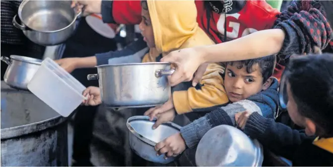  ?? MOHAMMED SALEM (REUTERS) ?? Niños palestinos esperaban ayer para recibir comida de una cocina de caridad en Rafah, en el sur de la franja de Gaza.